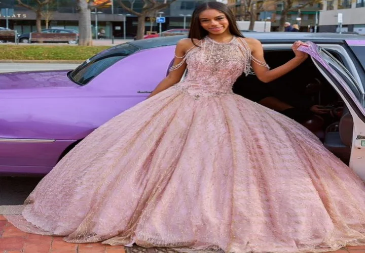 Quinceañera disfrutando de su fiesta en una limusina rosa en Barcelona, rodeada de luces