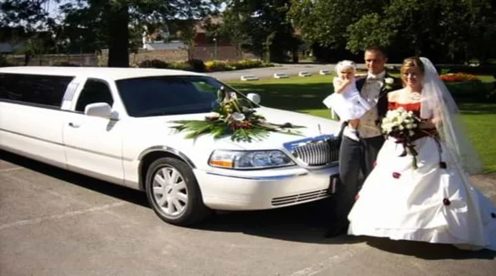 Limusina Lincoln blanca para boda en Limusina Barcelona Alquiler Limusinas, con una pareja de novios posando junto a su hijo, destacando elegancia y un momento familiar especial